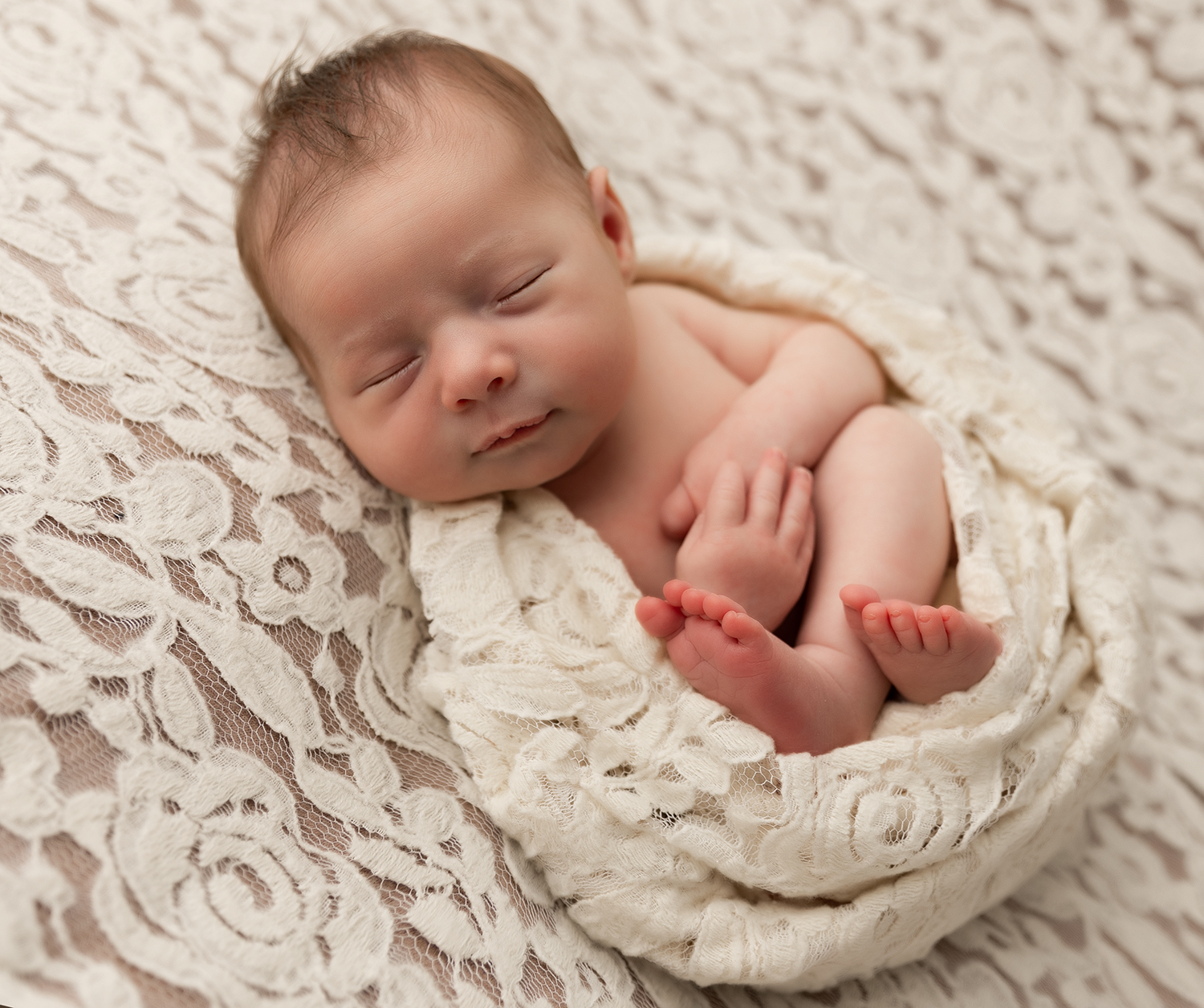 Newborn photo of a baby wrapped in a lace in an Erie PA Studio