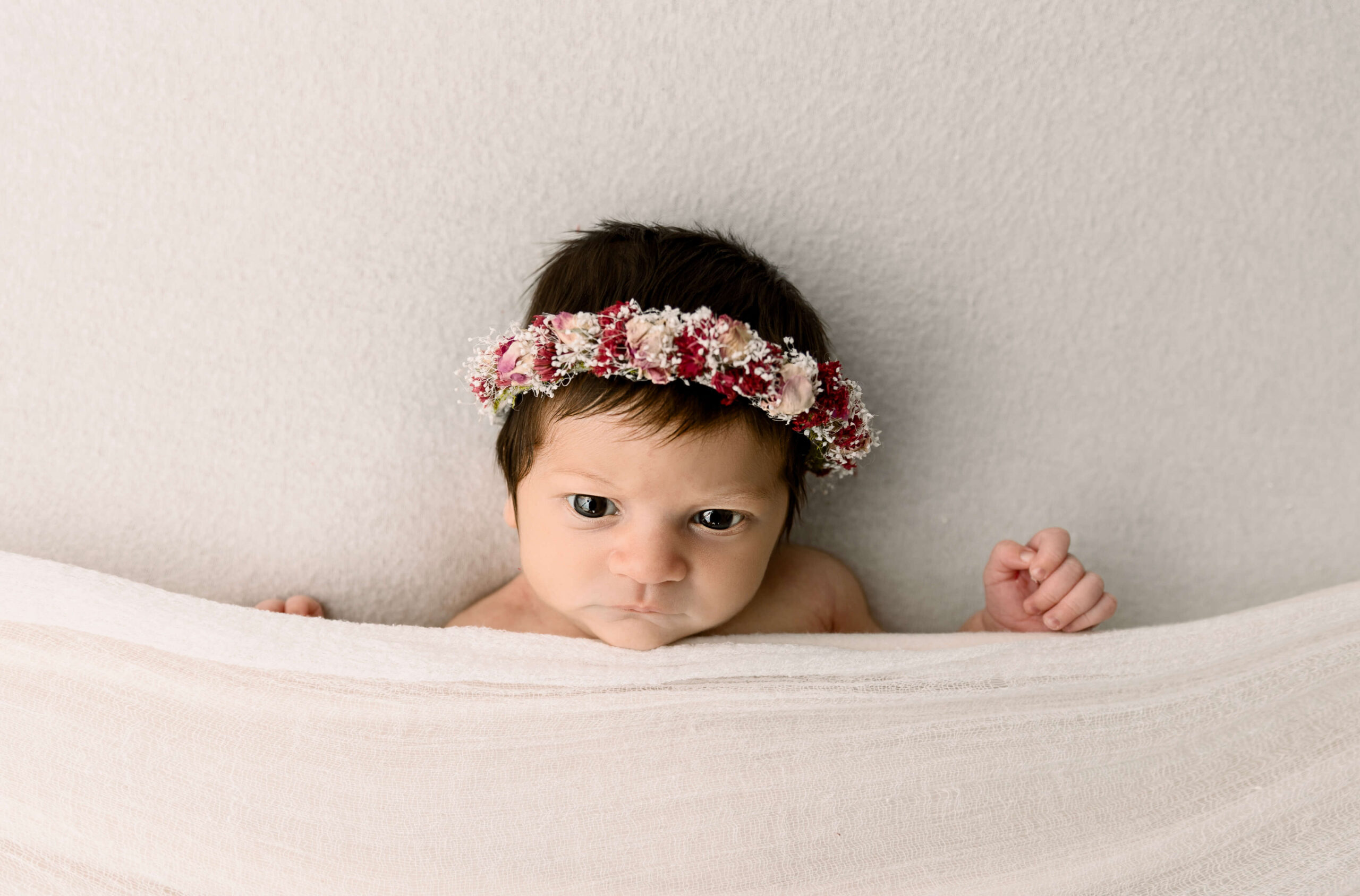 Newborn baby girl with a beautiful flower headband
