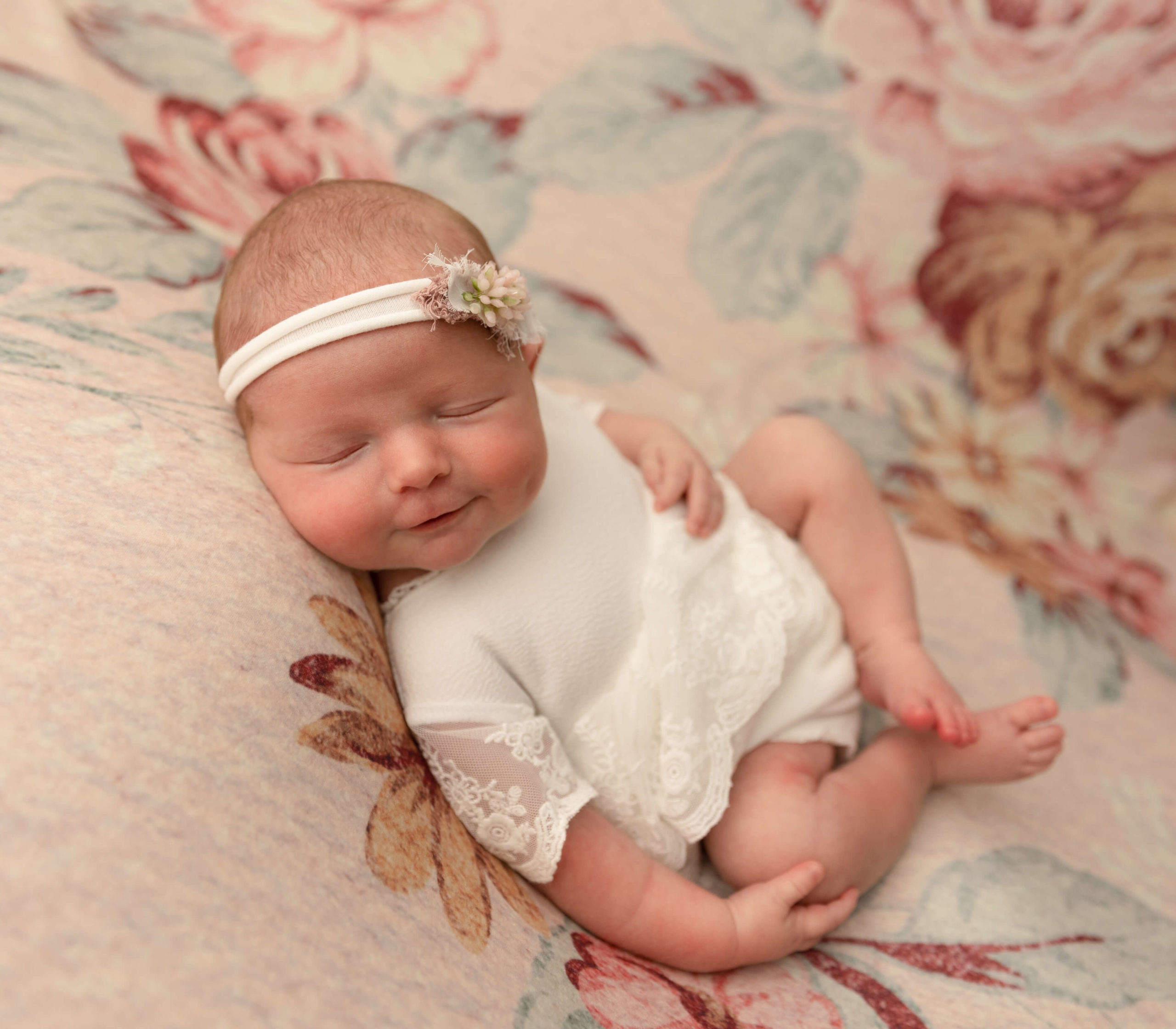 Photo of a newborn baby girl posed on her back in an Erie Pa Studio