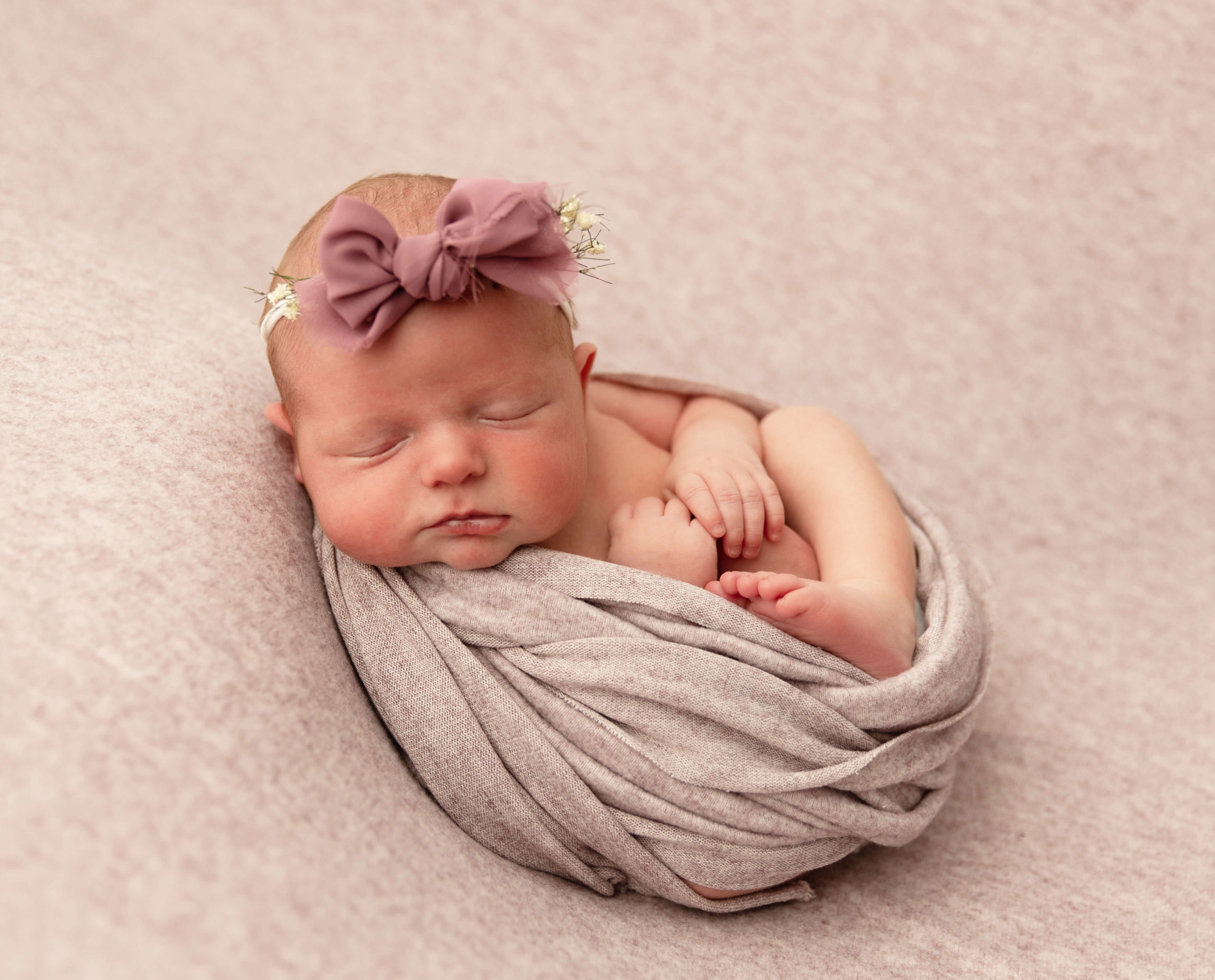 Newborn baby girl wrapping in a pink wrap