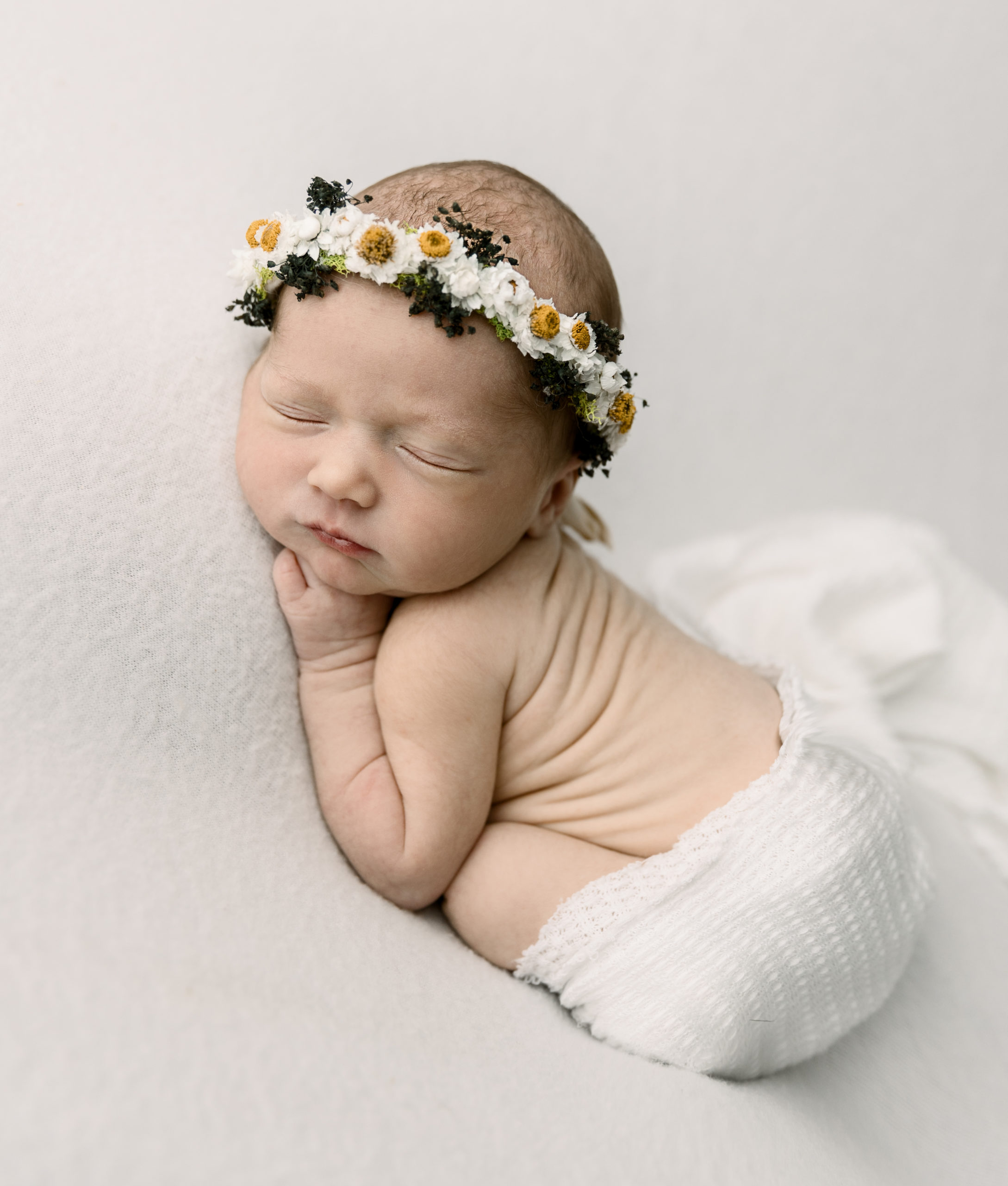 Newborn photo of a baby girl with a beautiful daisy headband