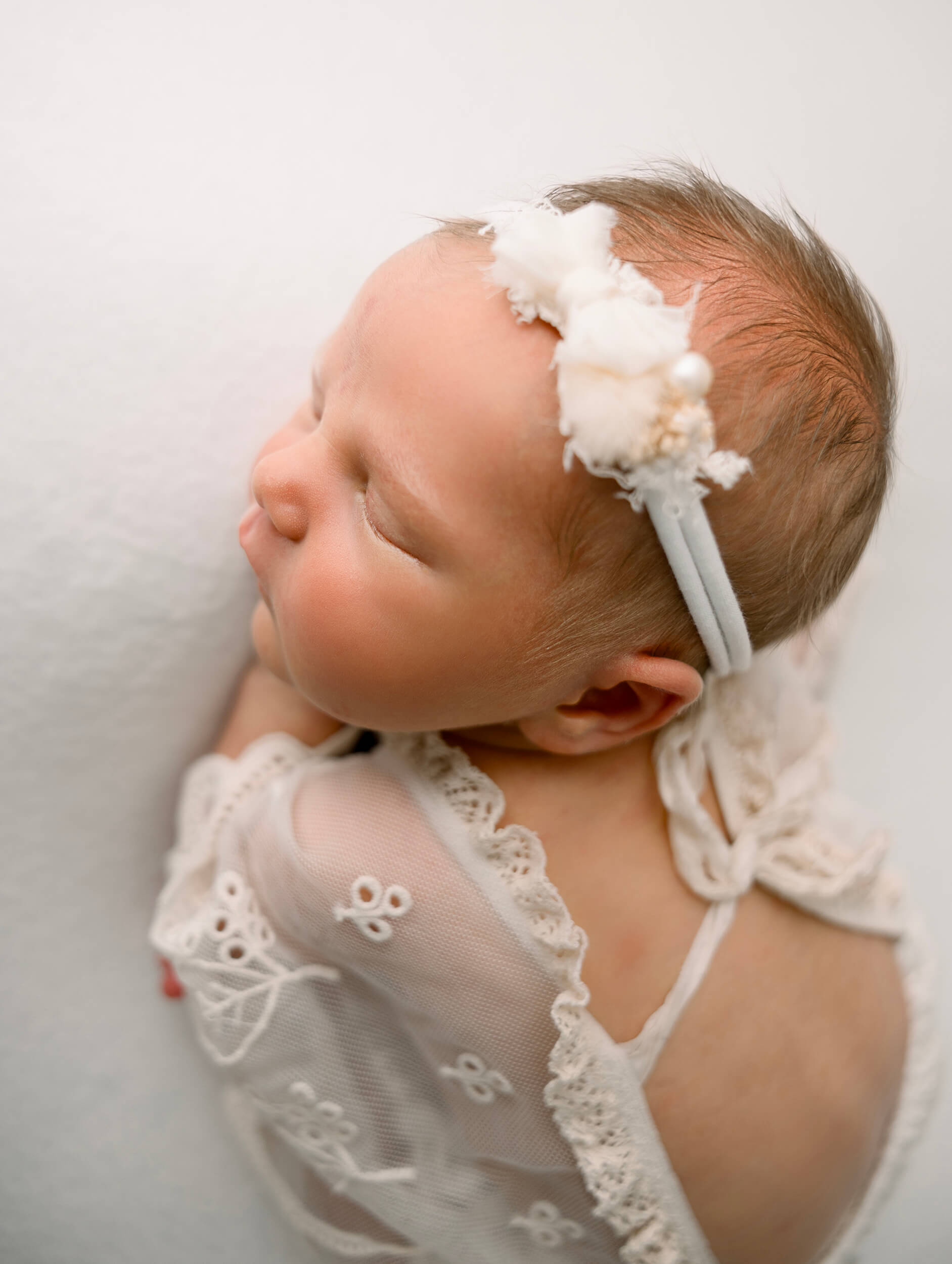 Newborn baby girl laying on a white blank in an Erie Pa Photography studio