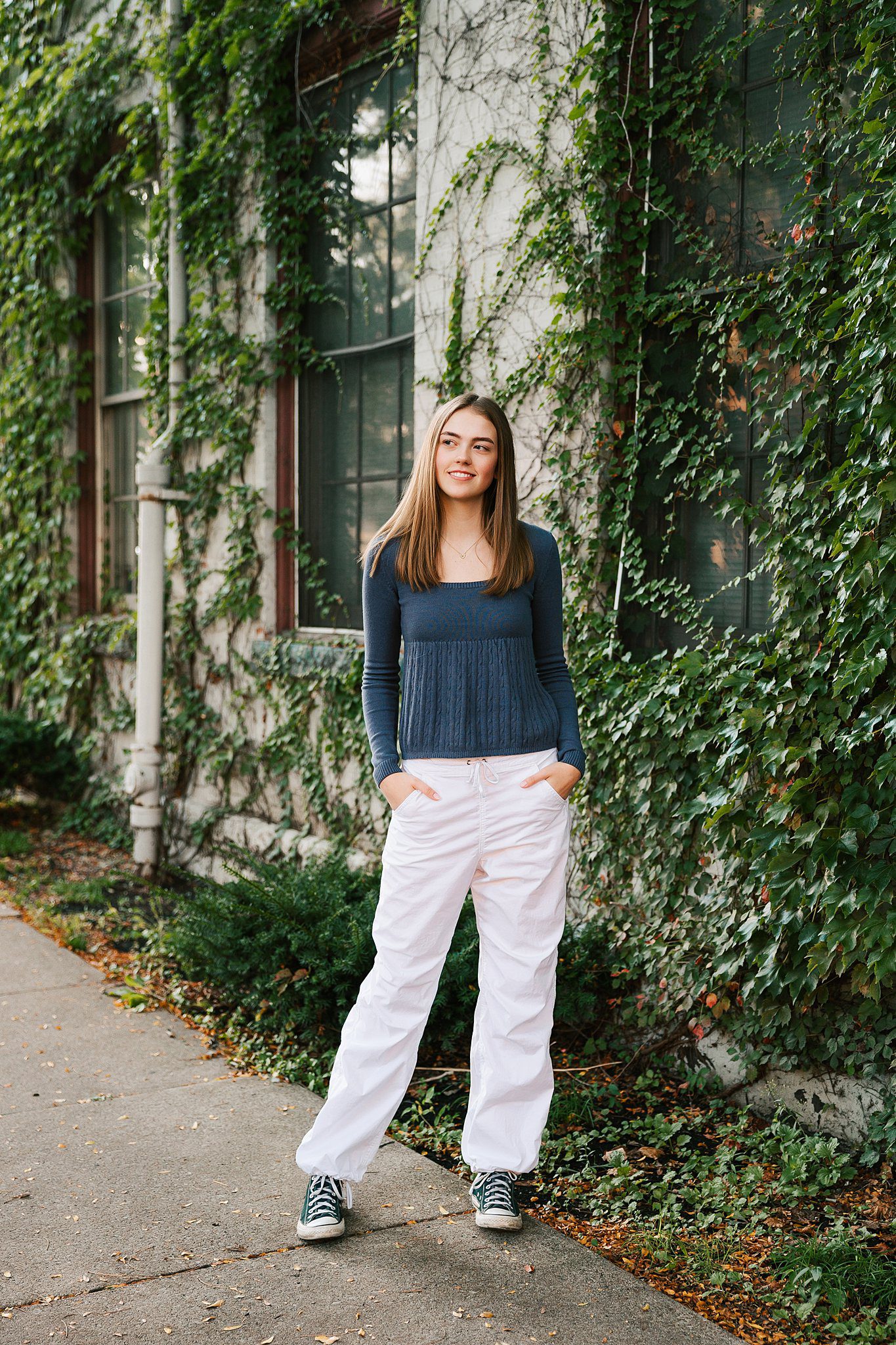 A high school senior stands by an ivy covered wall with hands in her pockets after using tutoring erie pa